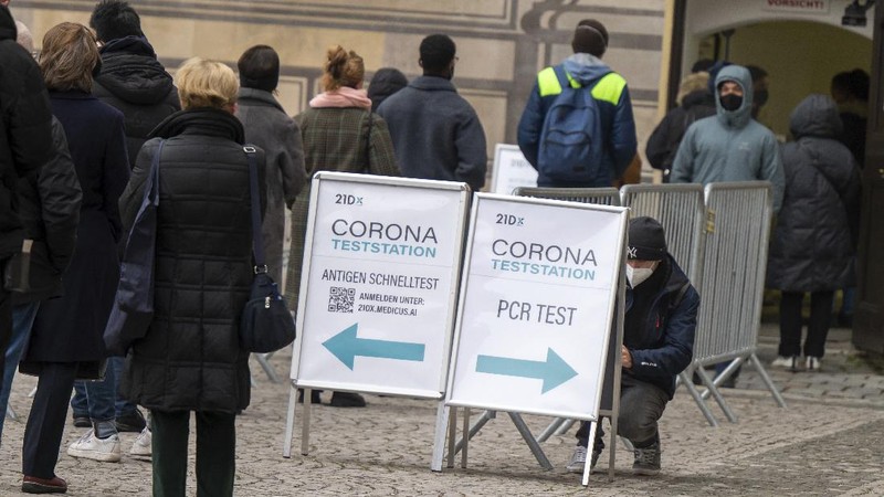 A sign indicating COVID-19 restrictions of mandatory masks hangs on a post along a pedestrian street in Flensburg, Germany, Wednesday, Nov. 24, 2021.(Roland Weihrauch/dpa via AP)