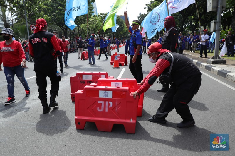 Ratusan buruh yang tergabung dalam FSP LEM SPSI, KSPI menutup jalur utama depan Gedung BalaiKota Jakarta, Kamis (25/11/2021). Demo buruh mengusung dua agenda, memprotes penetapan UMP 2022 dinilai terlalu kecil dan mengawal putusan MK soal uji materi UU Cipta Kerja. Pantauan dilokasi buruh perlahan meninggal aksi demo di patung kuda dan menutup jalan utama depan gedung Balaikota. Pengendara yang terjebak kemacetan hanya pasrah dan diputar balikan ke arah Stasiun Gambir, Jakarta. Puluhan polisi jugat erlihat mengamankan gedung Balaikota.(CNBC Indonesia/ Tri Susilo)