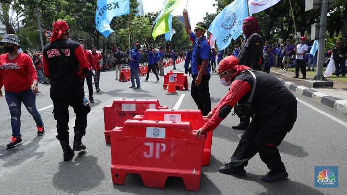 Demo Buruh Tolak Omnibus UMP di Balai Kota Jakarta Ratusan buruh yang tergabung dalam FSP LEM SPSI, KSPI menutup jalur utama depan Gedung BalaiKota Jakarta, Kamis (25/11/2021). Demo buruh mengusung dua agenda, memprotes penetapan UMP 2022 dinilai terlalu kecil dan mengawal putusan MK soal uji materi UU Cipta Kerja. Pantauan dilokasi buruh perlahan meninggal aksi demo di patung kuda dan menutup jalan utama depan gedung Balaikota. Pengendara yang terjebak kemacetan hanya pasrah dan diputar balikan ke arah Stasiun Gambir, Jakarta. Puluhan polisi jugat erlihat mengamankan gedung Balaikota.(CNBC Indonesia/ Tri Susilo)