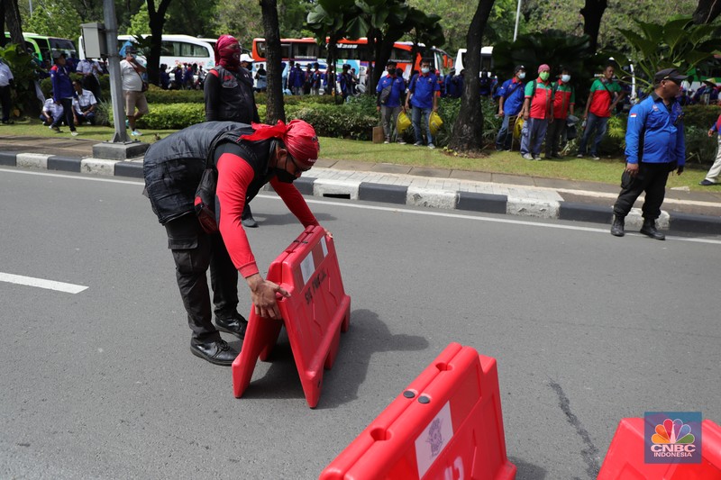 Demo Buruh Tolak Omnibus UMP di Balai Kota Jakarta Ratusan buruh yang tergabung dalam FSP LEM SPSI, KSPI menutup jalur utama depan Gedung BalaiKota Jakarta, Kamis (25/11/2021). Demo buruh mengusung dua agenda, memprotes penetapan UMP 2022 dinilai terlalu kecil dan mengawal putusan MK soal uji materi UU Cipta Kerja. Pantauan dilokasi buruh perlahan meninggal aksi demo di patung kuda dan menutup jalan utama depan gedung Balaikota. Pengendara yang terjebak kemacetan hanya pasrah dan diputar balikan ke arah Stasiun Gambir, Jakarta. Puluhan polisi jugat erlihat mengamankan gedung Balaikota.(CNBC Indonesia/ Tri Susilo)