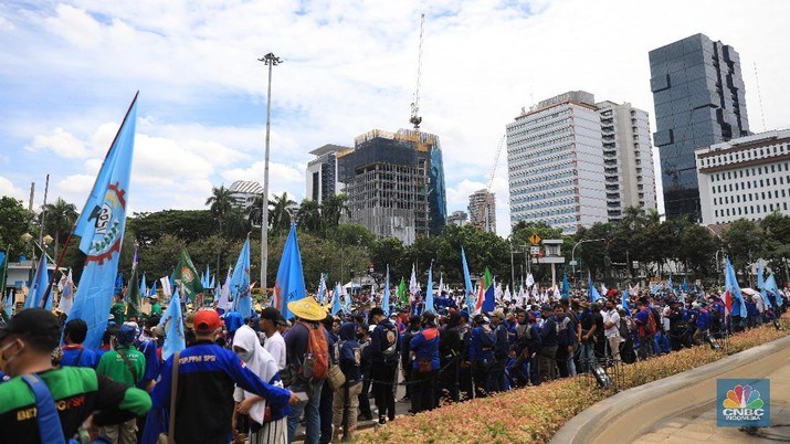 Demo Buruh Tolak UMP Aksi demonstrasi massa buruh patung Kuda di depan Kantor Gubernur DKI Jakarta, Kamis, 25/11. Ribuan buruh di berbagai wilayah di Indonesia, mulai dari Jakarta sampai Jawa Timur akan menggelar demonstrasi menolak penetapan Upah Minimum Provinsi (UMP). Di Jakarta, Pantauan CNBC Indonesia ratusan buruh yang tergabung dalam Konfederasi Serikat Pekerja Seluruh Indonesia (KSPSI) tertahan di Patung Kuda sebagai pusat titik demo. Buruh yang mengendarai motor mendorong dari depan Kantor Gubernur sampai Patung Kuda. Yel-yel dan kibaran mereka suarakan untuk menyemangati para demonstran. Aksi demo hari ini juga bertepatan dengan keputusan Mahkamah Konstitusi terkait judicial review atau uji formil terhadap UU Nomor 11 Tahun 2020 tentang Cipta Kerja (UU Cipta Kerja). (CNBC Indonesia/ Muhammad Sabki)