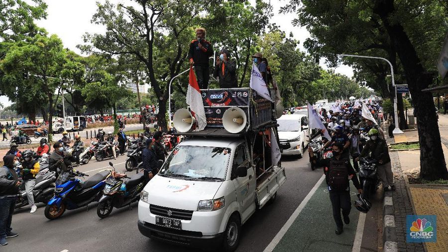 Masa buruh berjalan menuju arah patung Kuda di depan Kantor Gubernur DKI Jakarta, Kamis, 25/11. Ribuan buruh di berbagai wilayah di Indonesia, mulai dari Jakarta sampai Jawa Timur akan menggelar demonstrasi menolak penetapan Upah Minimum Provinsi (UMP). Di Jakarta, Pantauan CNBC Indonesia ratusan buruh yang tergabung dalam Konfederasi Serikat Pekerja Seluruh Indonesia (KSPSI)  berjalan demo menuju Patung Kuda sebagai pusat titik demo. Buruh yang mengendarai motor mendorong dari depan Kantor Gubernur sampai Patung Kuda. Yel-yel dan kibaran mereka suarakan untuk menyemangati para demonstran. Aksi demo hari ini juga bertepatan dengan keputusan Mahkamah Konstitusi terkait judicial review atau uji formil terhadap UU Nomor 11 Tahun 2020 tentang Cipta Kerja (UU Cipta Kerja).
 (CNBC Indonesia/ Muhammad Sabki)