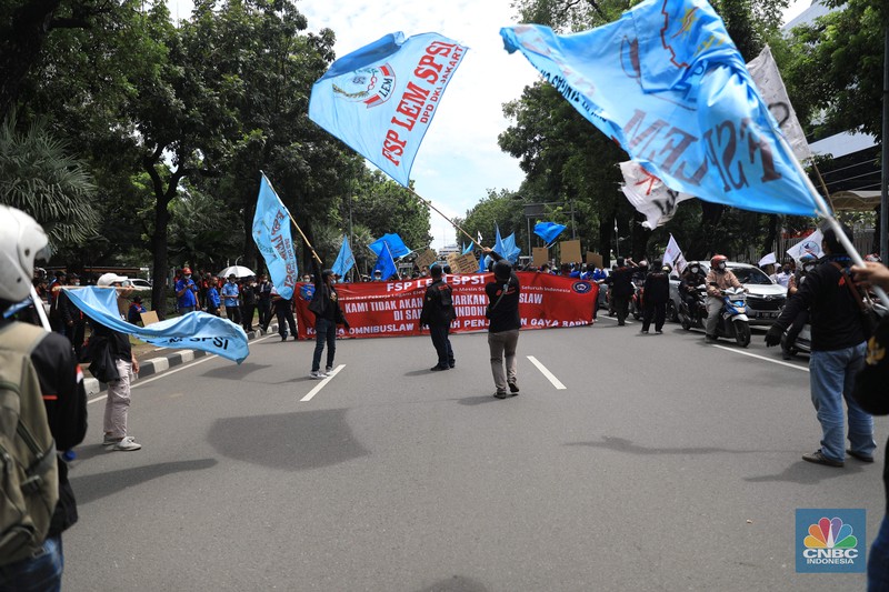 Masa buruh berjalan menuju arah patung Kuda di depan Kantor Gubernur DKI Jakarta, Kamis, 25/11. Ribuan buruh di berbagai wilayah di Indonesia, mulai dari Jakarta sampai Jawa Timur akan menggelar demonstrasi menolak penetapan Upah Minimum Provinsi (UMP). Di Jakarta, Pantauan CNBC Indonesia ratusan buruh yang tergabung dalam Konfederasi Serikat Pekerja Seluruh Indonesia (KSPSI)  berjalan demo menuju Patung Kuda sebagai pusat titik demo. Buruh yang mengendarai motor mendorong dari depan Kantor Gubernur sampai Patung Kuda. Yel-yel dan kibaran mereka suarakan untuk menyemangati para demonstran. Aksi demo hari ini juga bertepatan dengan keputusan Mahkamah Konstitusi terkait judicial review atau uji formil terhadap UU Nomor 11 Tahun 2020 tentang Cipta Kerja (UU Cipta Kerja).
 (CNBC Indonesia/ Muhammad Sabki)