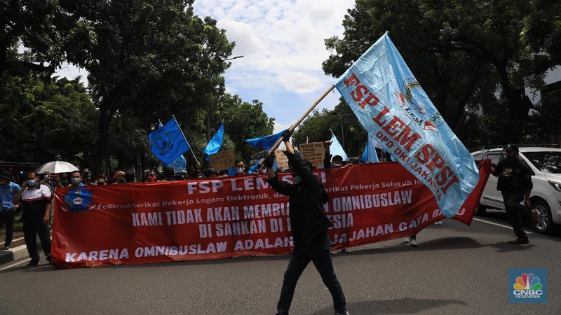 Masa buruh berjalan menuju arah patung Kuda di depan Kantor Gubernur DKI Jakarta, Kamis, 25/11. Ribuan buruh di berbagai wilayah di Indonesia, mulai dari Jakarta sampai Jawa Timur akan menggelar demonstrasi menolak penetapan Upah Minimum Provinsi (UMP). Di Jakarta, Pantauan CNBC Indonesia ratusan buruh yang tergabung dalam Konfederasi Serikat Pekerja Seluruh Indonesia (KSPSI)  berjalan demo menuju Patung Kuda sebagai pusat titik demo. Buruh yang mengendarai motor mendorong dari depan Kantor Gubernur sampai Patung Kuda. Yel-yel dan kibaran mereka suarakan untuk menyemangati para demonstran. Aksi demo hari ini juga bertepatan dengan keputusan Mahkamah Konstitusi terkait judicial review atau uji formil terhadap UU Nomor 11 Tahun 2020 tentang Cipta Kerja (UU Cipta Kerja).
 (CNBC Indonesia/ Muhammad Sabki)