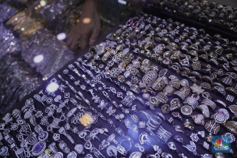Ilustrasi Perhiasan Perak Petugas menunjukkan cincin perak di pasar mas Cikini, Senin, 22/11. Harga perak dunia turun pada perdagangan ini di tengah kebimbangan antara potensi inflasi yang lebih tinggi dan sikap The Fed yang menahan suku bunga. Harga perak di pasar spot tercatat US$ 15,0200/troy ons, turun 0,12% . Pantauan CNBC Indonesia di lokasi. Harga perak terpantau stabil Di toko Bukit Mas, harga perak dijual per-ring seharga Rp700 ribu. Di Toko Yossi berlian perak dijual per gram seharga Rp200 ribu. (CNBC Indonesia/ Muhammad Sabki)