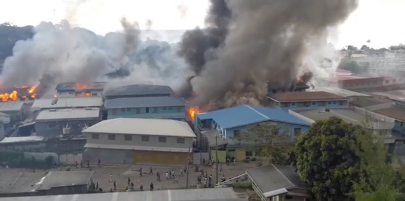Kerusuhan di Solomon Asap mengepul dari gedung-gedung yang terbakar selama protes di ibu kota Honiara, Kepulauan Solomon, Kamis (25/11/2021). (Australian Broadcasting Corporation via AP)