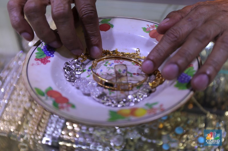 Saiful (48) melakukan proses pencucian gelang silver di salah satu pasar di Jakarta, Kamis (25/11/2021). 
Meski mengalami penurunan pendapatan hingga hampir 50% akibat pandemi Covid-19, para pengrajin cuci perhiasan tetap bertahan. Berbekal sejumlah alat sederhana yang terjajar di depannya, pria berusia 48 tahun tersebut tampak terampil tatkala membersihkan perhiasan-perhiasan milik pelanggannya. Menurut Saiful 