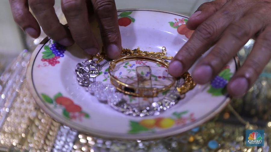 Saiful (48) melakukan proses pencucian gelang silver di salah satu pasar di Jakarta, Kamis (25/11/2021). 
Meski mengalami penurunan pendapatan hingga hampir 50% akibat pandemi Covid-19, para pengrajin cuci perhiasan tetap bertahan. Berbekal sejumlah alat sederhana yang terjajar di depannya, pria berusia 48 tahun tersebut tampak terampil tatkala membersihkan perhiasan-perhiasan milik pelanggannya. Menurut Saiful 