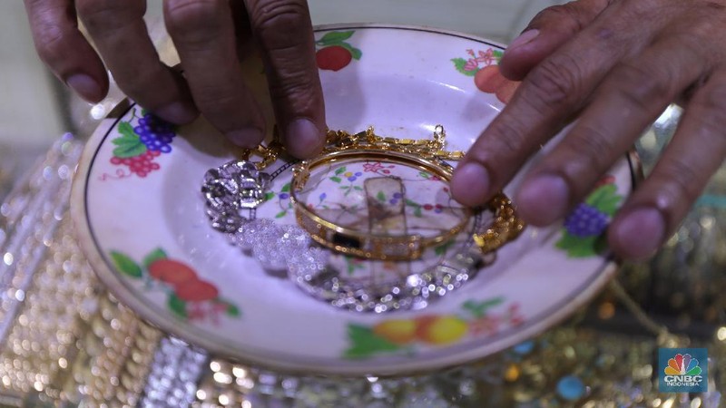 Saiful (48) melakukan proses pencucian gelang silver di salah satu pasar di Jakarta, Kamis (25/11/2021). 
Meski mengalami penurunan pendapatan hingga hampir 50% akibat pandemi Covid-19, para pengrajin cuci perhiasan tetap bertahan. Berbekal sejumlah alat sederhana yang terjajar di depannya, pria berusia 48 tahun tersebut tampak terampil tatkala membersihkan perhiasan-perhiasan milik pelanggannya. Menurut Saiful 