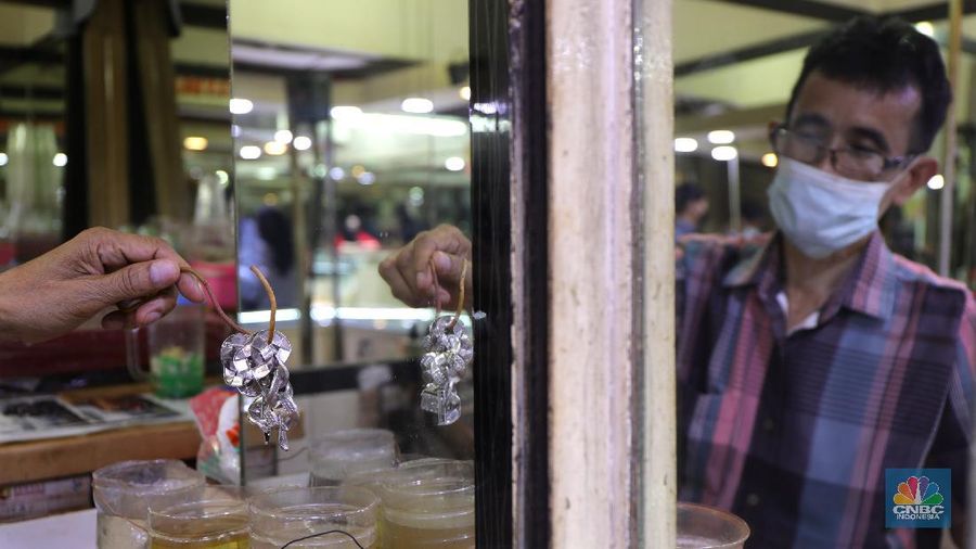 Saiful (48) melakukan proses pencucian gelang silver di salah satu pasar di Jakarta, Kamis (25/11/2021). 
Meski mengalami penurunan pendapatan hingga hampir 50% akibat pandemi Covid-19, para pengrajin cuci perhiasan tetap bertahan. Berbekal sejumlah alat sederhana yang terjajar di depannya, pria berusia 48 tahun tersebut tampak terampil tatkala membersihkan perhiasan-perhiasan milik pelanggannya. Menurut Saiful 
