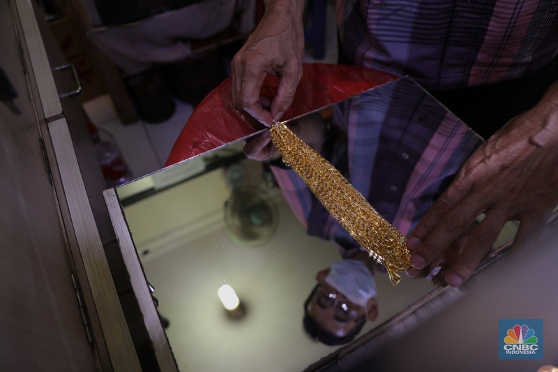 Saiful (48) melakukan proses pencucian gelang silver di salah satu pasar di Jakarta, Kamis (25/11/2021). 
Meski mengalami penurunan pendapatan hingga hampir 50% akibat pandemi Covid-19, para pengrajin cuci perhiasan tetap bertahan. Berbekal sejumlah alat sederhana yang terjajar di depannya, pria berusia 48 tahun tersebut tampak terampil tatkala membersihkan perhiasan-perhiasan milik pelanggannya. Menurut Saiful 