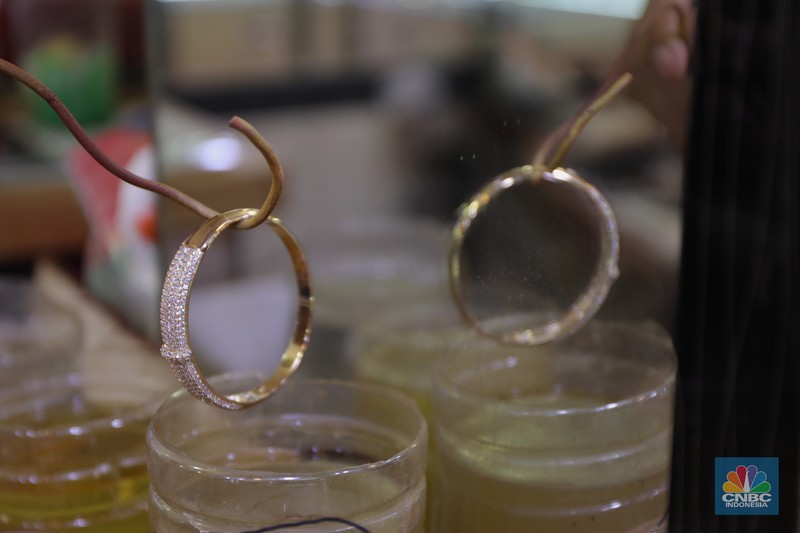 Saiful (48) melakukan proses pencucian gelang silver di salah satu pasar di Jakarta, Kamis (25/11/2021). 
Meski mengalami penurunan pendapatan hingga hampir 50% akibat pandemi Covid-19, para pengrajin cuci perhiasan tetap bertahan. Berbekal sejumlah alat sederhana yang terjajar di depannya, pria berusia 48 tahun tersebut tampak terampil tatkala membersihkan perhiasan-perhiasan milik pelanggannya. Menurut Saiful 