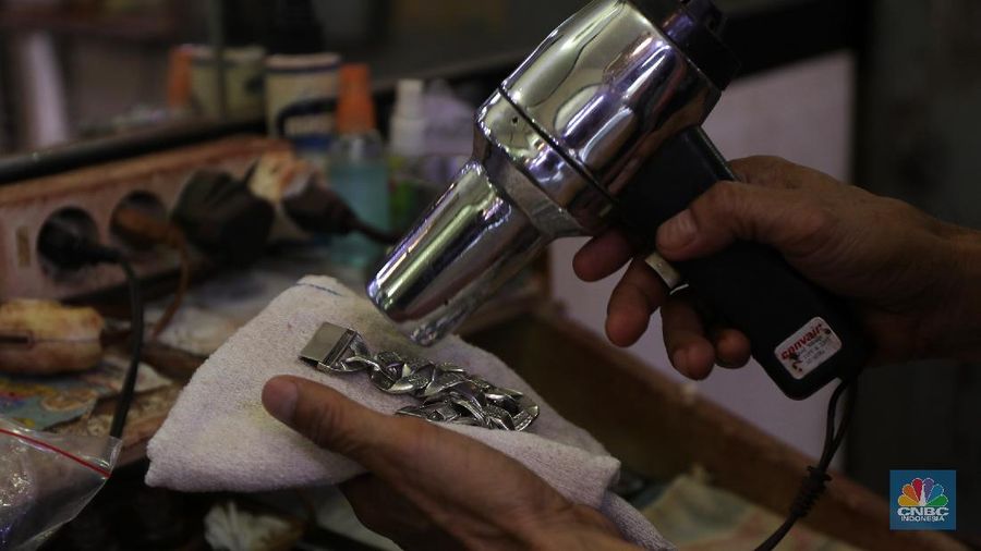 Saiful (48) melakukan proses pencucian gelang silver di salah satu pasar di Jakarta, Kamis (25/11/2021). 
Meski mengalami penurunan pendapatan hingga hampir 50% akibat pandemi Covid-19, para pengrajin cuci perhiasan tetap bertahan. Berbekal sejumlah alat sederhana yang terjajar di depannya, pria berusia 48 tahun tersebut tampak terampil tatkala membersihkan perhiasan-perhiasan milik pelanggannya. Menurut Saiful 