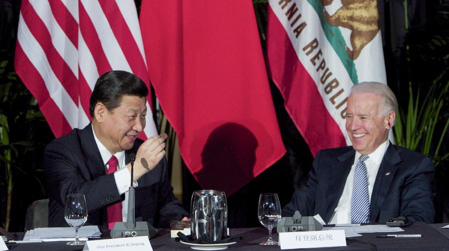 FILE - Xi Jinping, China's president and Communist Party chief, left, eats a Hawaiian macadamia chocolate gifted by Governor of Hawaii, Neil Abercrombie, not seen, during a governors meeting held inside the Walt Disney Concert Hall as Vice President Joe Biden, right, looks on in Los Angeles., Feb. 17, 2012. As President Joe Biden and Xi Jinping prepare to hold their first summit on Monday, Nov. 15, the increasingly fractured U.S.-China relationship has demonstrated that the ability to connect on a personal level has its limits. Biden nonetheless believes there is value in a face-to-face meeting, even a virtual one like the two leaders will hold Monday evening. (AP Photo/Damian Dovarganes, File)