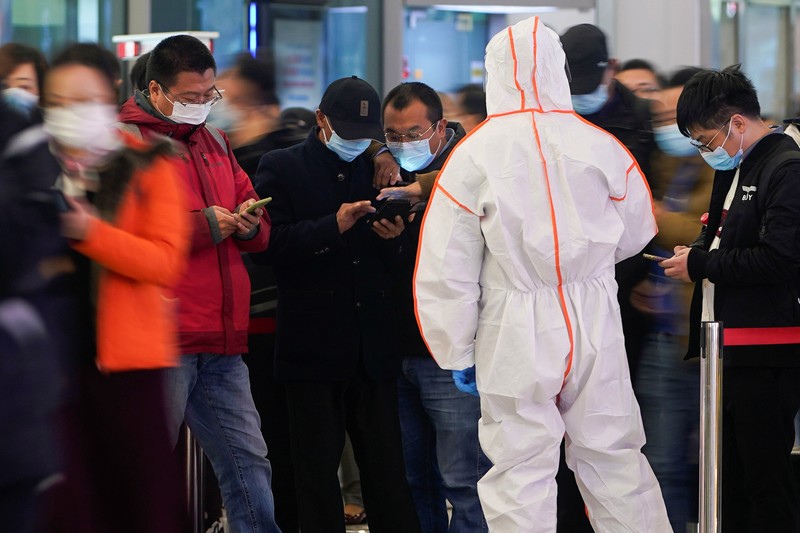 A security guard blocks an exit as he directs people to scan a QR code to track their health status at Shanghai Hongqiao Railway Station, following new cases of the coronavirus disease (COVID-19), in Shanghai, China, November 25, 2021. Picture taken November 25, 2021. (REUTERS/Aly Song)