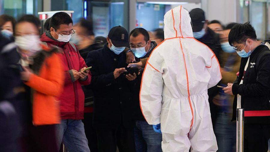 A security guard blocks an exit as he directs people to scan a QR code to track their health status at Shanghai Hongqiao Railway Station, following new cases of the coronavirus disease (COVID-19), in Shanghai, China, November 25, 2021. Picture taken November 25, 2021. (REUTERS/Aly Song)