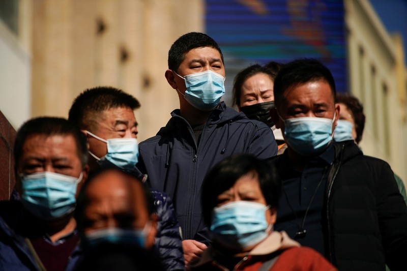A security guard blocks an exit as he directs people to scan a QR code to track their health status at Shanghai Hongqiao Railway Station, following new cases of the coronavirus disease (COVID-19), in Shanghai, China, November 25, 2021. Picture taken November 25, 2021. (REUTERS/Aly Song)