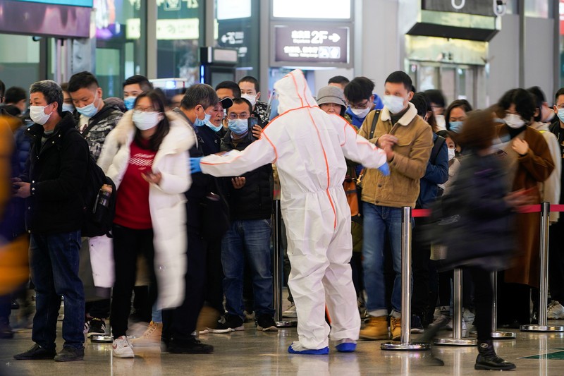 A security guard blocks an exit as he directs people to scan a QR code to track their health status at Shanghai Hongqiao Railway Station, following new cases of the coronavirus disease (COVID-19), in Shanghai, China, November 25, 2021. Picture taken November 25, 2021. (REUTERS/Aly Song)