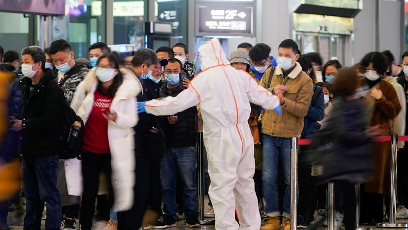 A security guard blocks an exit as he directs people to scan a QR code to track their health status at Shanghai Hongqiao Railway Station, following new cases of the coronavirus disease (COVID-19), in Shanghai, China, November 25, 2021. Picture taken November 25, 2021. (REUTERS/Aly Song)