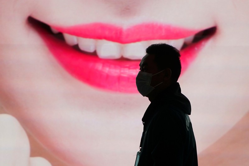 A security guard blocks an exit as he directs people to scan a QR code to track their health status at Shanghai Hongqiao Railway Station, following new cases of the coronavirus disease (COVID-19), in Shanghai, China, November 25, 2021. Picture taken November 25, 2021. (REUTERS/Aly Song)