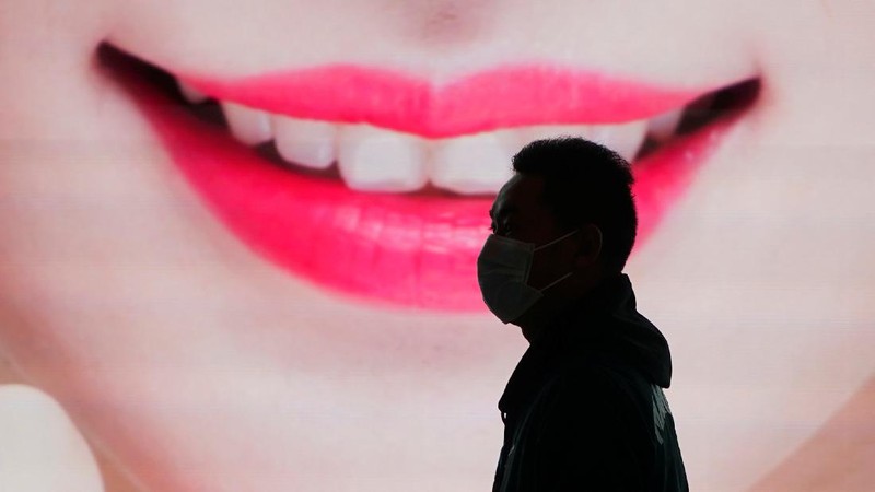 A security guard blocks an exit as he directs people to scan a QR code to track their health status at Shanghai Hongqiao Railway Station, following new cases of the coronavirus disease (COVID-19), in Shanghai, China, November 25, 2021. Picture taken November 25, 2021. (REUTERS/Aly Song)