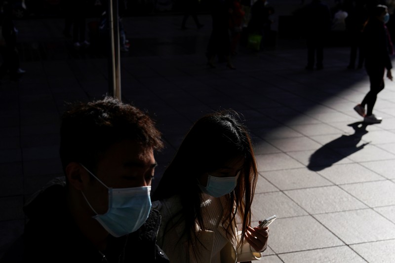 A security guard blocks an exit as he directs people to scan a QR code to track their health status at Shanghai Hongqiao Railway Station, following new cases of the coronavirus disease (COVID-19), in Shanghai, China, November 25, 2021. Picture taken November 25, 2021. (REUTERS/Aly Song)