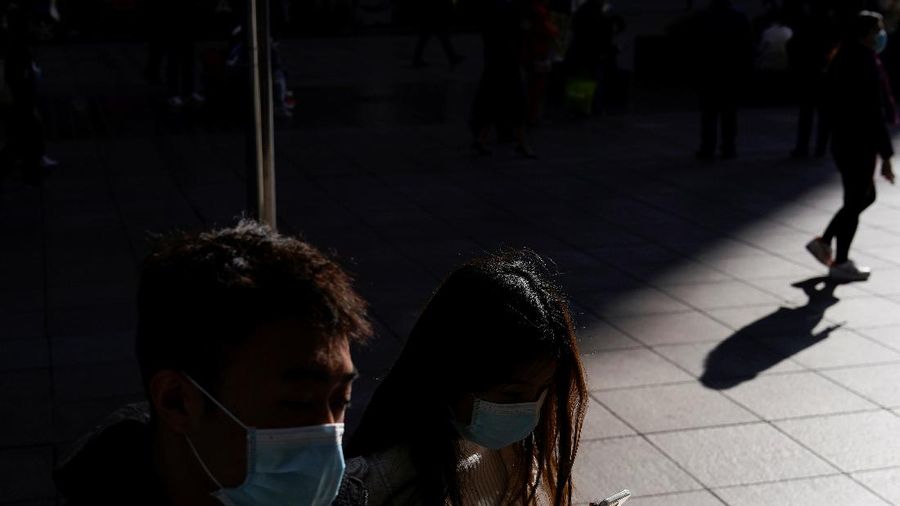 A security guard blocks an exit as he directs people to scan a QR code to track their health status at Shanghai Hongqiao Railway Station, following new cases of the coronavirus disease (COVID-19), in Shanghai, China, November 25, 2021. Picture taken November 25, 2021. (REUTERS/Aly Song)