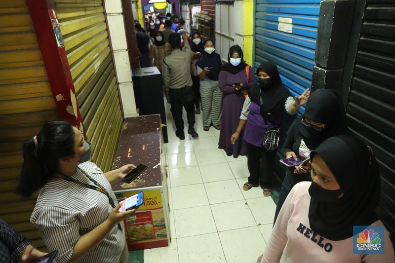 Ratusan warga antre untuk mendapatkan minyak curah kemasan di salah satu pasar di Jakarta, Jumat (26/11/2021). Program yang dilakukan oleh Pasar Jaya berkerja sama dengan Bank DKI berupa Rp. 20.000 ribu subsidi mendapatkan 2 liter + bonus 1 liter minyak curah. Sebelumnya, warga harus menginstal aplikasi Jakone  dan mengikuti persyaratan yang tertera di aplikasi. 
Suherman salah satu pedagang gorengan mengatakan 