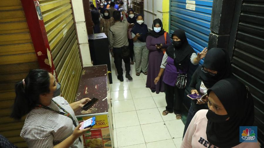 Ratusan warga antre untuk mendapatkan minyak curah kemasan di salah satu pasar di Jakarta, Jumat (26/11/2021). Program yang dilakukan oleh Pasar Jaya berkerja sama dengan Bank DKI berupa Rp. 20.000 ribu subsidi mendapatkan 2 liter + bonus 1 liter minyak curah. Sebelumnya, warga harus menginstal aplikasi Jakone  dan mengikuti persyaratan yang tertera di aplikasi. 
Suherman salah satu pedagang gorengan mengatakan 