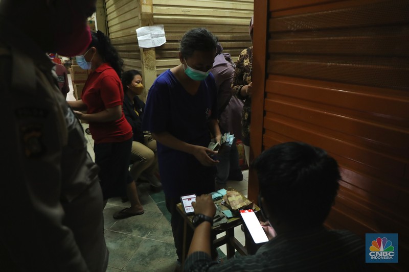 Ratusan warga antre untuk mendapatkan minyak curah kemasan di salah satu pasar di Jakarta, Jumat (26/11/2021). Program yang dilakukan oleh Pasar Jaya berkerja sama dengan Bank DKI berupa Rp. 20.000 ribu subsidi mendapatkan 2 liter + bonus 1 liter minyak curah. Sebelumnya, warga harus menginstal aplikasi Jakone  dan mengikuti persyaratan yang tertera di aplikasi. 
Suherman salah satu pedagang gorengan mengatakan 