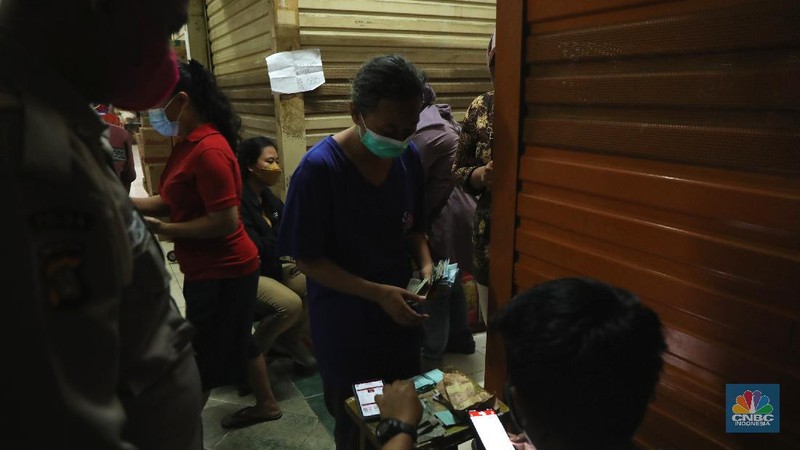 Ratusan warga antre untuk mendapatkan minyak curah kemasan di salah satu pasar di Jakarta, Jumat (26/11/2021). Program yang dilakukan oleh Pasar Jaya berkerja sama dengan Bank DKI berupa Rp. 20.000 ribu subsidi mendapatkan 2 liter + bonus 1 liter minyak curah. Sebelumnya, warga harus menginstal aplikasi Jakone  dan mengikuti persyaratan yang tertera di aplikasi. 
Suherman salah satu pedagang gorengan mengatakan 