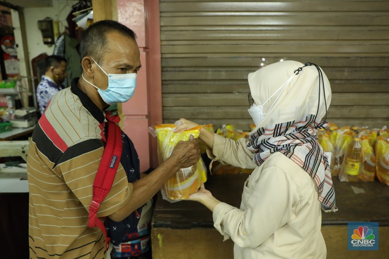 Ratusan warga antre untuk mendapatkan minyak curah kemasan di salah satu pasar di Jakarta, Jumat (26/11/2021). Program yang dilakukan oleh Pasar Jaya berkerja sama dengan Bank DKI berupa Rp. 20.000 ribu subsidi mendapatkan 2 liter + bonus 1 liter minyak curah. Sebelumnya, warga harus menginstal aplikasi Jakone  dan mengikuti persyaratan yang tertera di aplikasi. 
Suherman salah satu pedagang gorengan mengatakan 