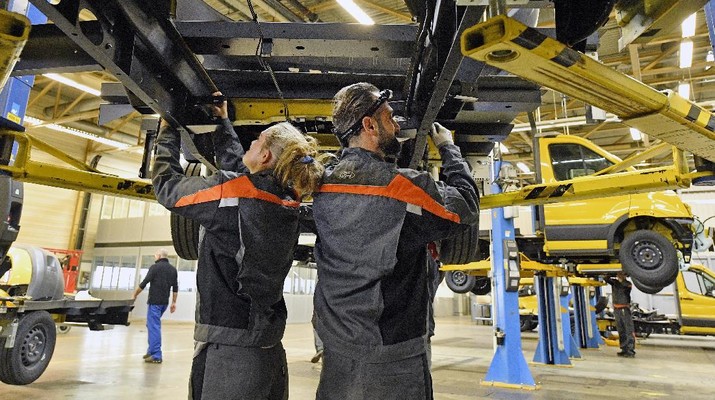 StreetScooter Workers assemble the new Deutsche Post StreetScooter Work XL electric delivery van at the Ford car plant in Cologne, Germany, Tuesday, Oct. 9, 2018. US carmaker Ford just started the production of the full electric van based on a Ford Transit chassis in cooperation with StreetScooter for the DHL Group at its manufacturing site in Cologne, offering an annual production capacity of 3,500 units. (AP Photo/Martin Meissner)
