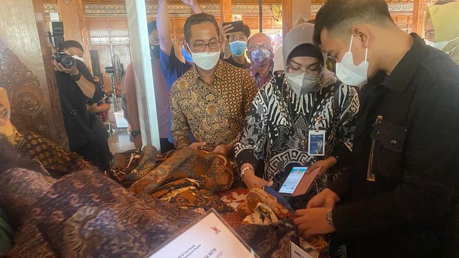Walikota Surakarta Gibran Rakabuming Raka berbincang dengan Wakil Direktur Utama BNI Adi Sulistyowati ditemani oleh Direktur Layanan dan Jaringan BNI Ronny Venir saat bertransaksi menggunakan QRIS BNI Mobile Banking, Jumat (26/11/2021).