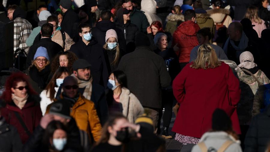 Kerumunan terjadi saat Omicron memasuki Inggris. (REUTERS/TOM NICHOLSON)