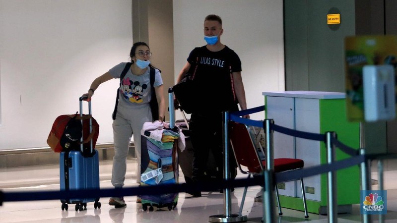 Penumpang WNA tengah berjalan saat tiba di ruang kedatangan di Terminal 3 Bandara Soetta, Tangerang, Banten, Senin (29/11/2021). Pemerintah memutuskan untuk menambah waktu karantina bagi WNA dan WNI yang masuk ke Indonesia untuk mencegah penyebaran Covid-19 varian baru, Omicron. (CNBC Indonesia/Muhammad Sabki)