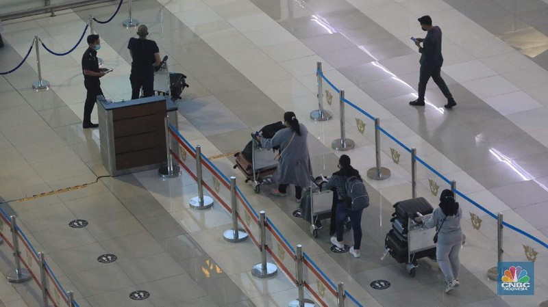 Penumpang WNA tengah berjalan saat tiba di ruang kedatangan di Terminal 3 Bandara Soetta, Tangerang, Banten, Senin (29/11/2021). Pemerintah memutuskan untuk menambah waktu karantina bagi WNA dan WNI yang masuk ke Indonesia untuk mencegah penyebaran Covid-19 varian baru, Omicron. (CNBC Indonesia/Muhammad Sabki)
