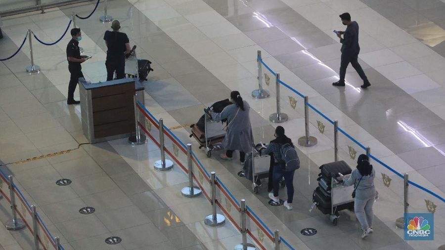 Penumpang WNA tengah berjalan saat tiba di ruang kedatangan di Terminal 3 Bandara Soetta, Tangerang, Banten, Senin (29/11/2021). Pemerintah memutuskan untuk menambah waktu karantina bagi WNA dan WNI yang masuk ke Indonesia untuk mencegah penyebaran Covid-19 varian baru, Omicron. (²©²ÊÍøÕ¾/Muhammad Sabki)