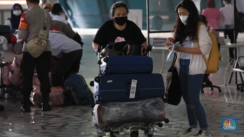 Penumpang WNA tengah berjalan saat tiba di ruang kedatangan di Terminal 3 Bandara Soetta, Tangerang, Banten, Senin (29/11/2021). Pemerintah memutuskan untuk menambah waktu karantina bagi WNA dan WNI yang masuk ke Indonesia untuk mencegah penyebaran Covid-19 varian baru, Omicron. (CNBC Indonesia/Muhammad Sabki)