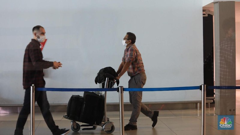 Penumpang WNA tengah berjalan saat tiba di ruang kedatangan di Terminal 3 Bandara Soetta, Tangerang, Banten, Senin (29/11/2021). Pemerintah memutuskan untuk menambah waktu karantina bagi WNA dan WNI yang masuk ke Indonesia untuk mencegah penyebaran Covid-19 varian baru, Omicron. (CNBC Indonesia/Muhammad Sabki)
