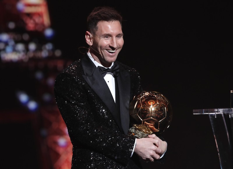 Lionel Messi memegang trofi Ballon d'Or 2021. (REUTERS/BENOIT TESSIER)