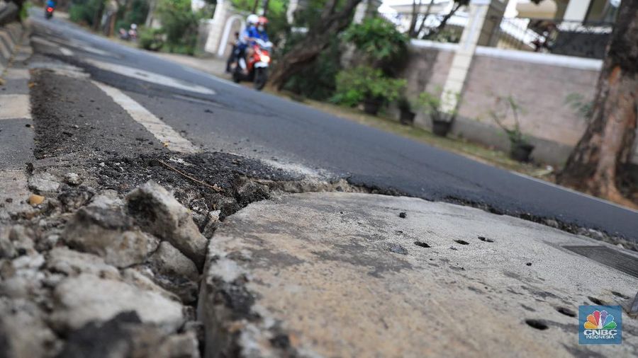 Pengendara motor melintas di samping galian proyek sumur resapan di jalan Lebak Bulus III, Jakarta, Selasa, (30/11/2021). (CNBC Indonesia/Muhammad Sabki)