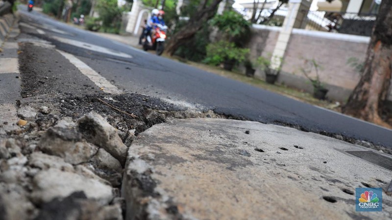 Pengendara motor melintas di samping galian proyek sumur resapan di jalan Lebak Bulus III, Jakarta, Selasa, (30/11/2021). (CNBC Indonesia/Muhammad Sabki)