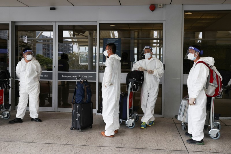 Warga mengunakan baju pelindung diri di bandara Australia. (via REUTERS/STRINGER)