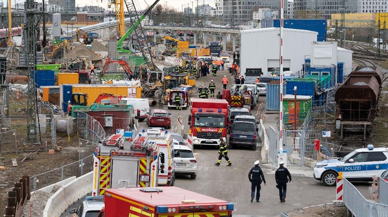 Pemadam kebakaran dan polisi bekerja di lokasi ledakan bom dekat stasiun kereta api utama di Munich, Jerman selatan, pada (1/12/2021). Menurut laporan media, empat orang terluka, salah satunya serius, saat Perang Kata Bom II meledak saat pekerjaan sedang berlangsung di lokasi konstruksi dekat dengan stasiun kereta api. (REUTERS/ANDREAS GEBERT)