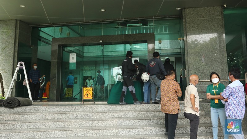 Pekerja membersihkan sisa sisa akibat kebakaran yang melanda Gedung Cyber 1, di Jalan Kuningan Barat Raya, Mampang Prapatan, Jakarta Selatan, Jumat (3/12/2021). (CNBC Indonesia/Andrean Kristianto)