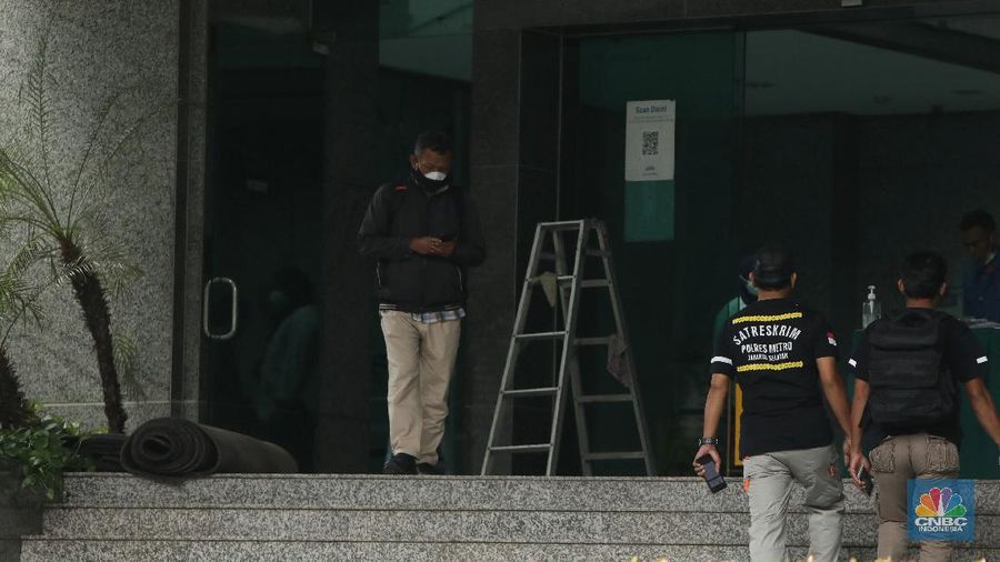 Pekerja membersihkan sisa sisa akibat kebakaran yang melanda Gedung Cyber 1, di Jalan Kuningan Barat Raya, Mampang Prapatan, Jakarta Selatan, Jumat (3/12/2021). (CNBC Indonesia/Andrean Kristianto)