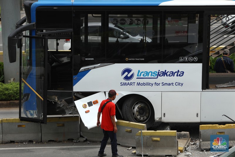 Petugas melihat kondisi bus Transjakarta yang mengalami kecelakaan di depan Ratu Plaza, Jakarta, Jumat (3/12/2021). (CNBC Indonesia/Andrean Kristianto)