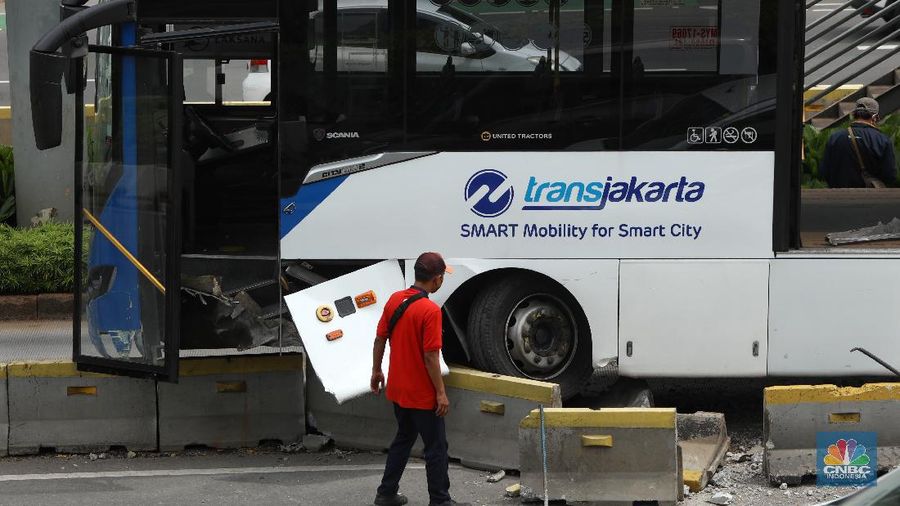 Petugas melihat kondisi bus Transjakarta yang mengalami kecelakaan di depan Ratu Plaza, Jakarta, Jumat (3/12/2021). (CNBC Indonesia/Andrean Kristianto)