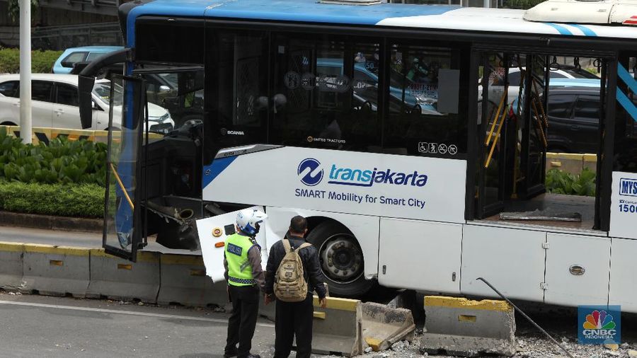 Petugas melihat kondisi bus Transjakarta yang mengalami kecelakaan di depan Ratu Plaza, Jakarta, Jumat (3/12/2021). (CNBC Indonesia/Andrean Kristianto)
